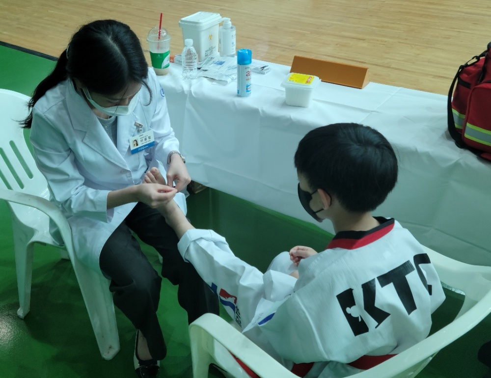 [사진설명] 분당자생한방병원 의료진이 국기원 승품•단 심사대회 중 부상당한 선수에게 침치료를 하고 있다.jpg