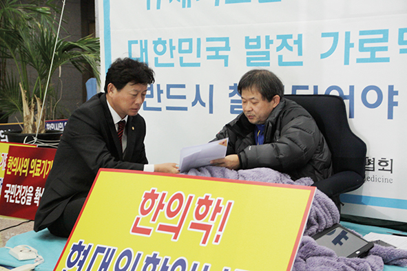 지난 2015년 2월 김명연 의원이 김필건 대한한의사협회장의 단식 투쟁 현장인 협회관을 방문해 한의사 의료기기 사용 문제 해결에 대해 논의하고 있다.